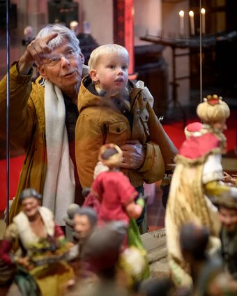 opa met kindje bij mooiste kerststal. Foto Mike Bink