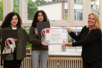 Wassila, Ghizlan en Hilal (niet op de foto) van X11 met hun foto van een Oeigoers meisje. Fotograaf: Femke Lockefeer
