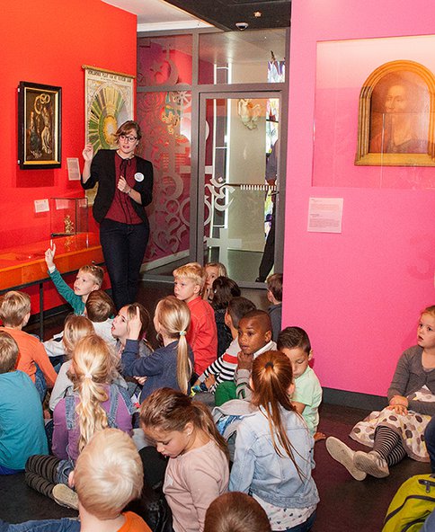 Een schoolklas krijgt uitleg in Feest! Weet wat je viert.