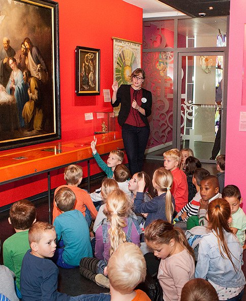 Een schoolklas krijgt uitleg in Feest! Weet wat je viert.